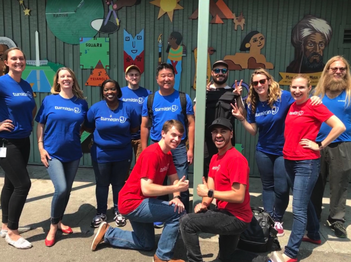 Group picture of Turnitin team members wearing matching blue and red shirts. 